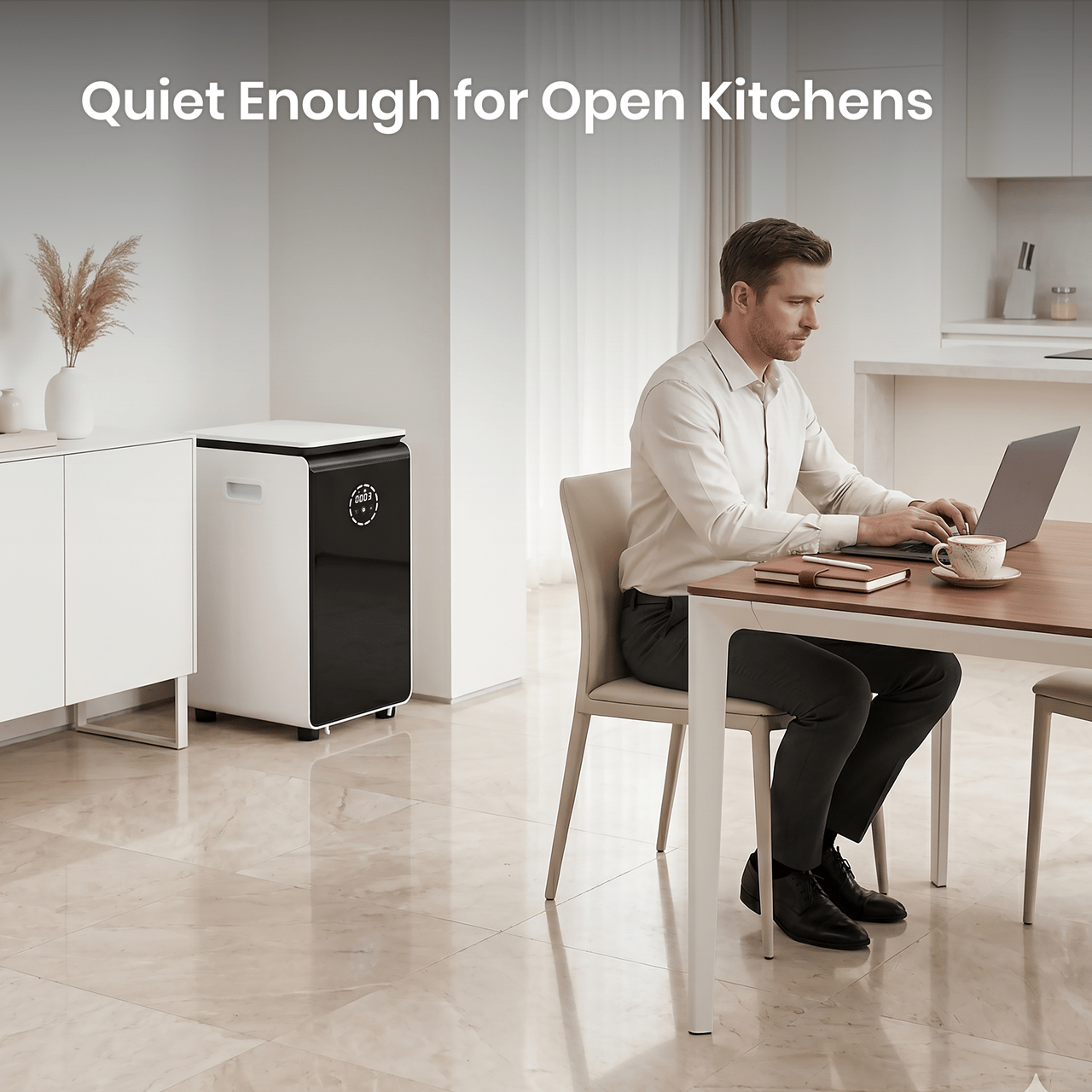 Man working on a laptop in a modern kitchen with a quiet GEME Composter Pro.